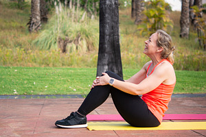 Woman resting after workout sitting on yoga mat outdoors, a Person Photo by etorres69