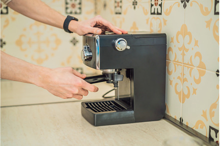 Handsome man using coffee machine in, a Person Photo by Elizaveta Galitskaya