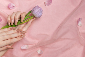Woman hands with perfect nude manicure holding purple tulip on p, a Beauty & Fashion Photo by Olena Rudo