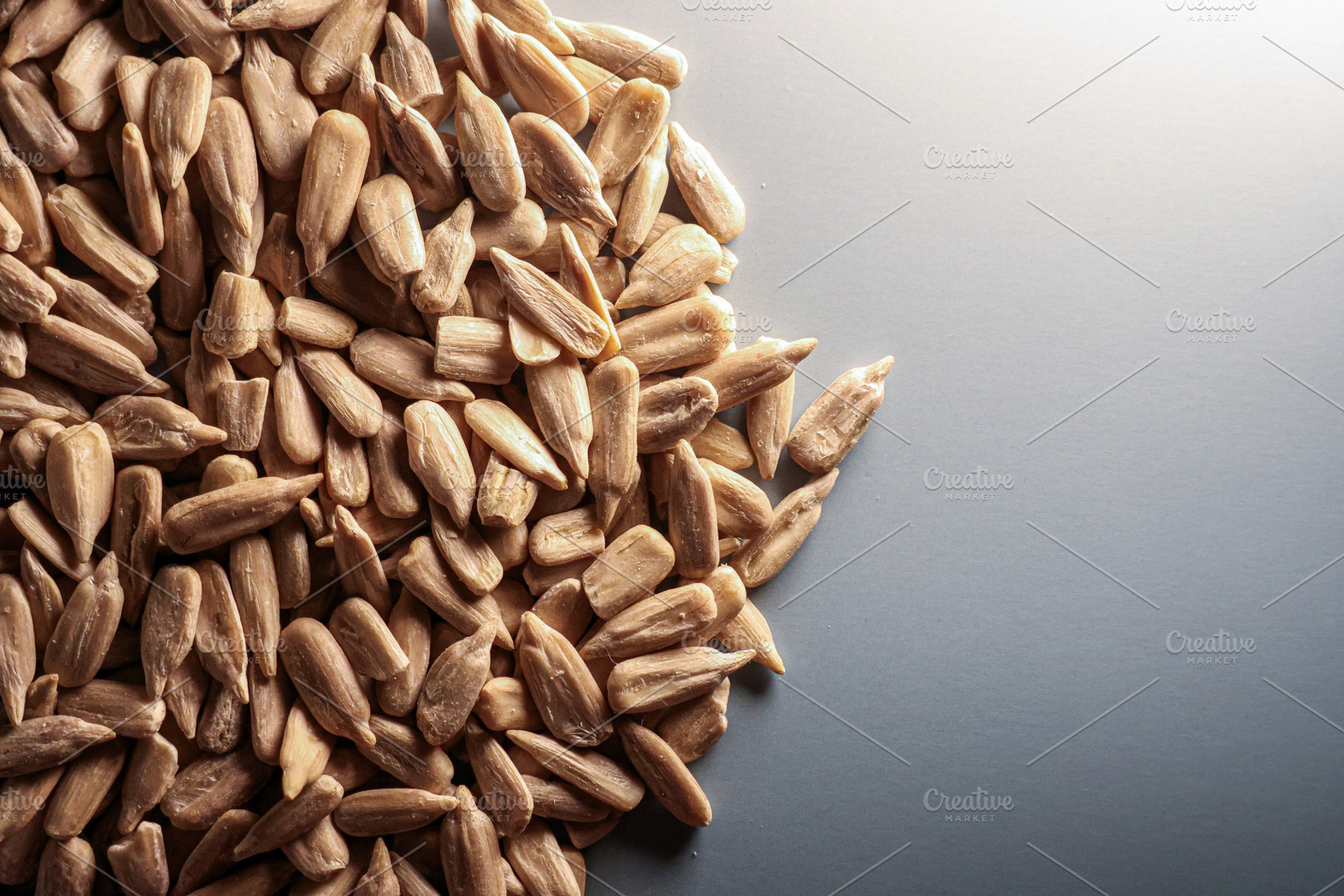 Peeled sunflower seeds forming a textured half frame with copy s, a Photo by Studio ANNA