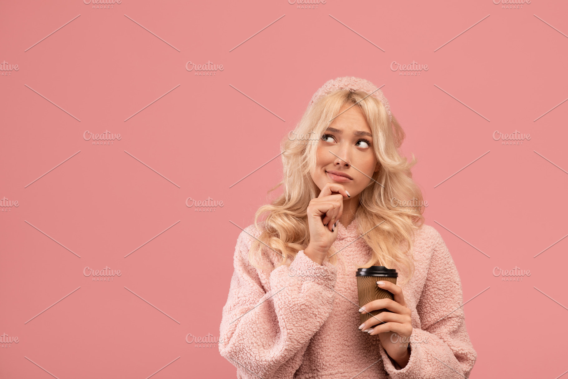 Pensive woman holding takeaway coffee and pondering on offer, looking aside at, a Photo by Prostock-Studio