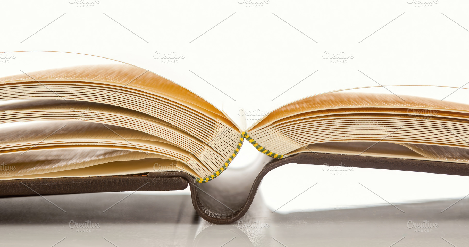 Open photo album showing thick pages and binding on white background, an Abstract Photo by Antonio Gravante Market