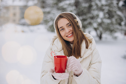Cute happy woman holding hot coffee with candy in winter park, a Holiday Photo by Cherkas Photography