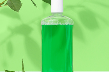 Refreshing mouthwash in a transparent plastic bottle on a green, a Health & Medical Photo by ndanko