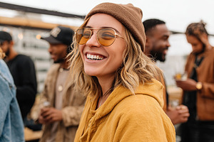 Smiling woman in yellow hoodie and sunglasses at a casual outdoor gathering wit, a Person Photo by AlyaAnd