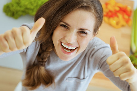 Happy young housewife in modern kitchen showing thumbs up, a Food & Drink Photo by Alliance Images