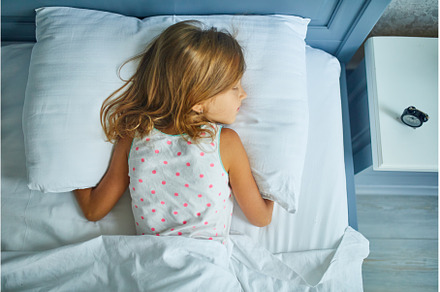 Little girl sleeping on a big and, a Person Photo by IlliaBondarPhotography