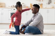 Cute little girl making birthday surprise for her dad, a Photo by Prostock-Studio (Thumbnail 1 of 2)