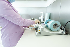 Nurse packing medical instruments using a sealing machine in clinic, a Health & Medical Photo by Antonio Gravante Market