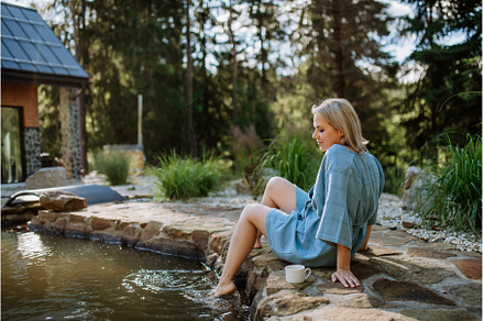 Happy young woman sitting by pond, a Sports & Recreation Photo by HalfPoint