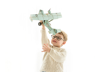 boy playing with airplane over white