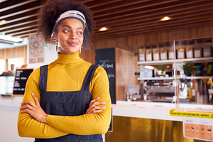 Female african coffee shop owner wea containing ppe, female, and coffee shop