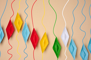 A row of multicolored origami paper boats with corresponding col, a Business Photo by ndanko