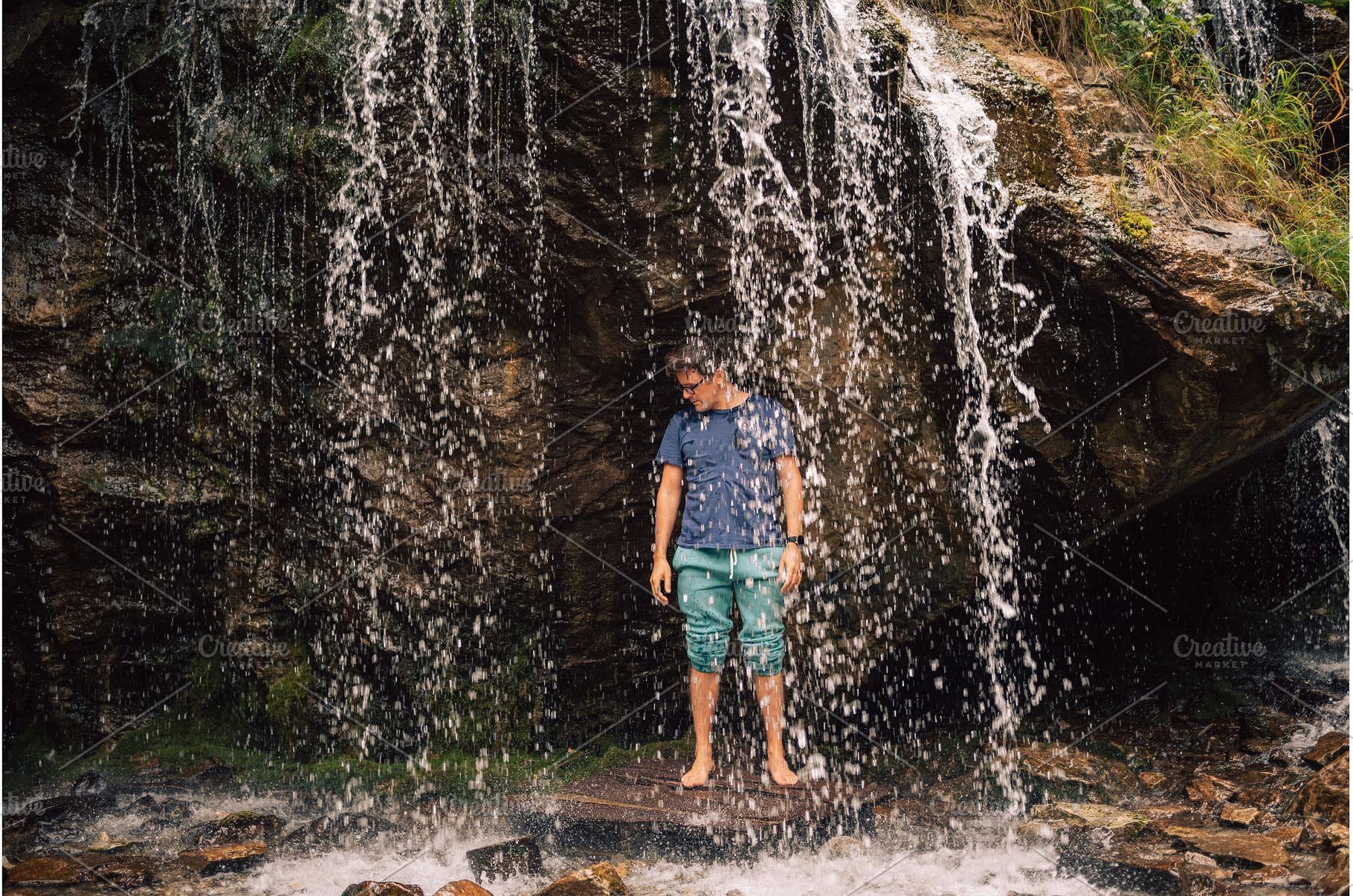 Man at waterfall in summer Altai, a Person Photo by Jan Jack Russo Media