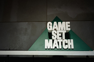 Minimalist sign with 'Game Set Match' displayed on a green triangle, a Photo by AS photostudio