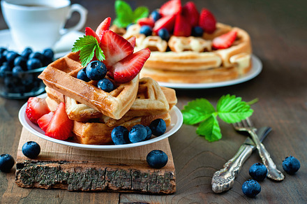 Belgian waffles with berries containing strawberry, blueberry, and maple