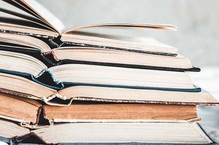 Opened books in a stack on a light featuring grunge, retro, and vintage