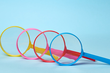 Multicolored plastic magnifying glasses on a blue background, a Business Photo by ndanko