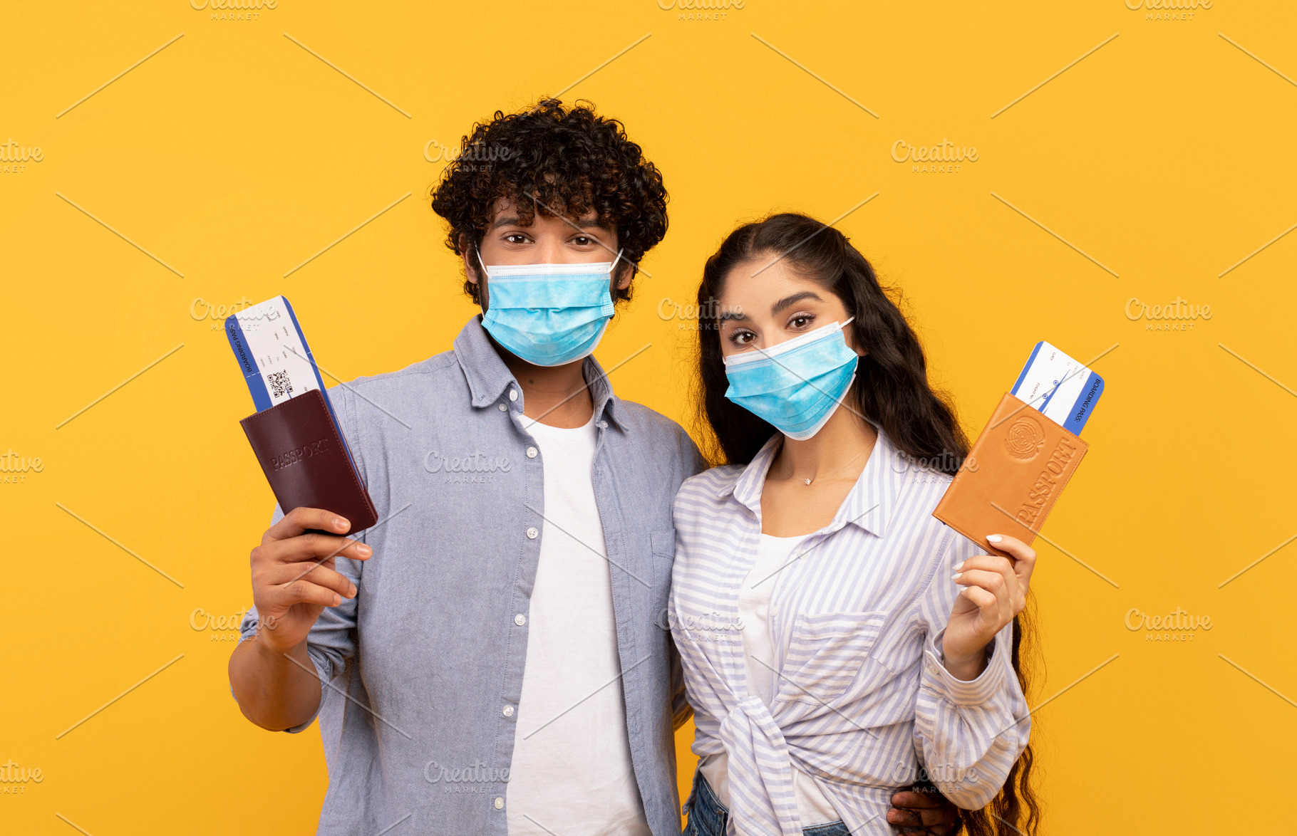 Young indian couple wearing protective face masks, holding passports and flight, a Person Photo by Prostock-Studio