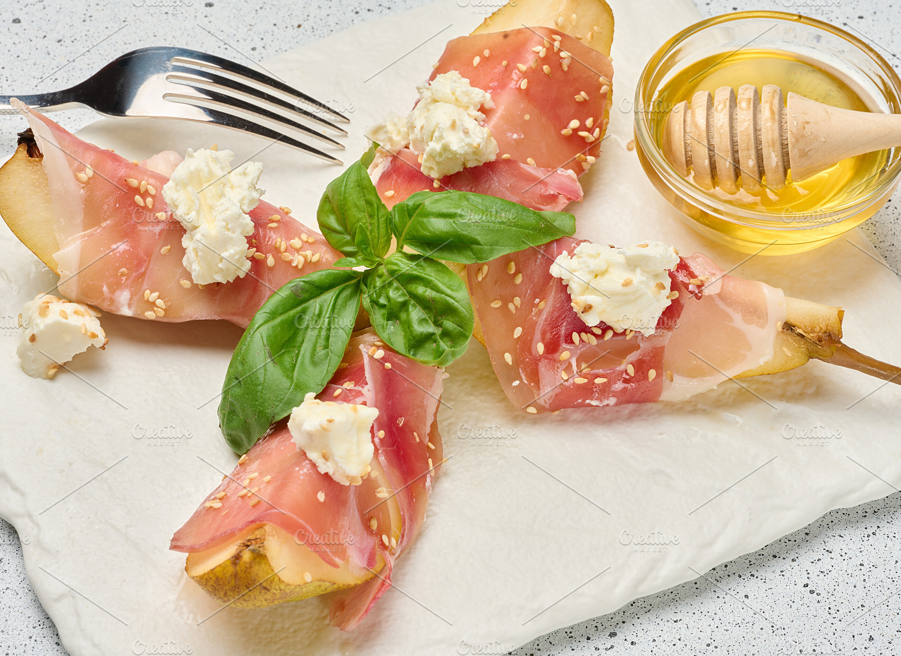 Pear slice wrapped in prosciutto with cheese and sesame seeds on, a Food & Drink Photo by ndanko