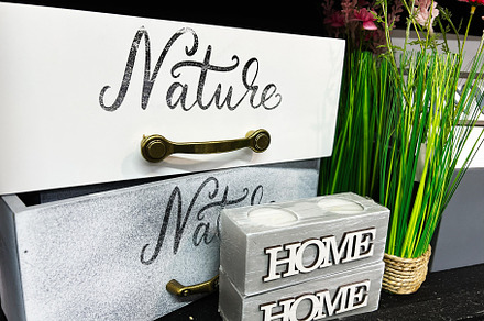 Decorative storage boxes with 'Nature' text and 'Home' block during floral arra, a Photo by AS photostudio