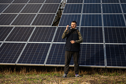 Man with mobile phone on the background of solar panels.  Eco en, a Technology Photo by AS photostudio