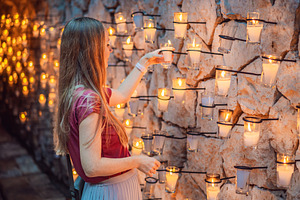 Woman exploring a warmly lit wall of, a Person Photo by Elizaveta Galitskaya