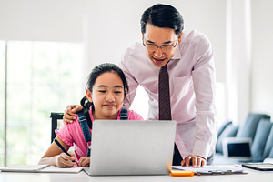 Father and asian kid little girl learning and looking at laptop