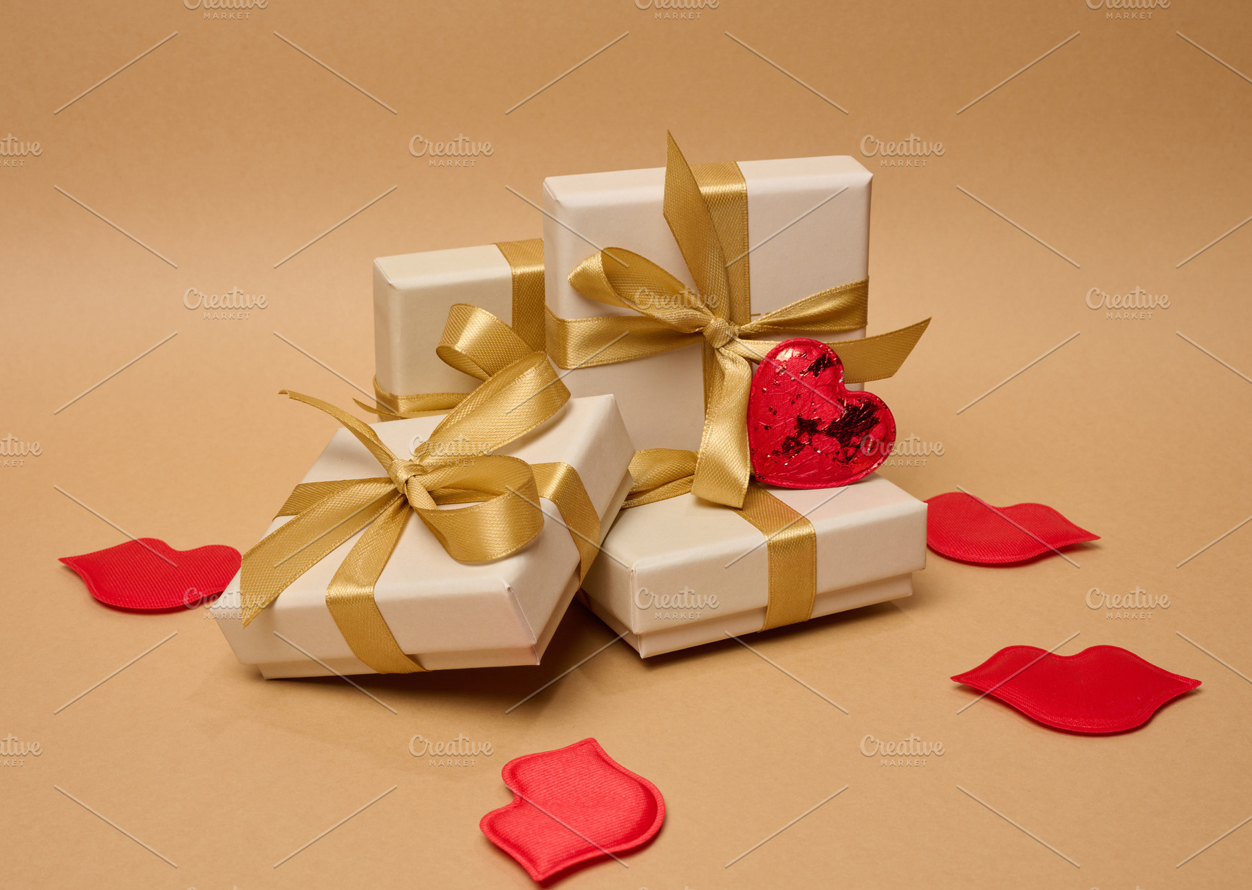 A stack of cream-colored gift boxes tied with gold satin ribbons, a Holiday Photo by ndanko