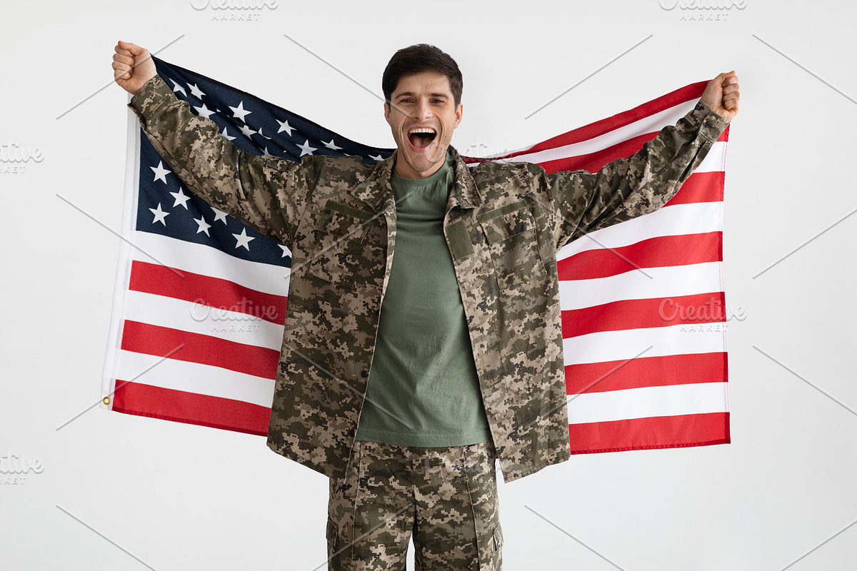 Cheerful military guy with flag of the US on white, a Photo by Prostock-Studio (Photo 1 of 4)