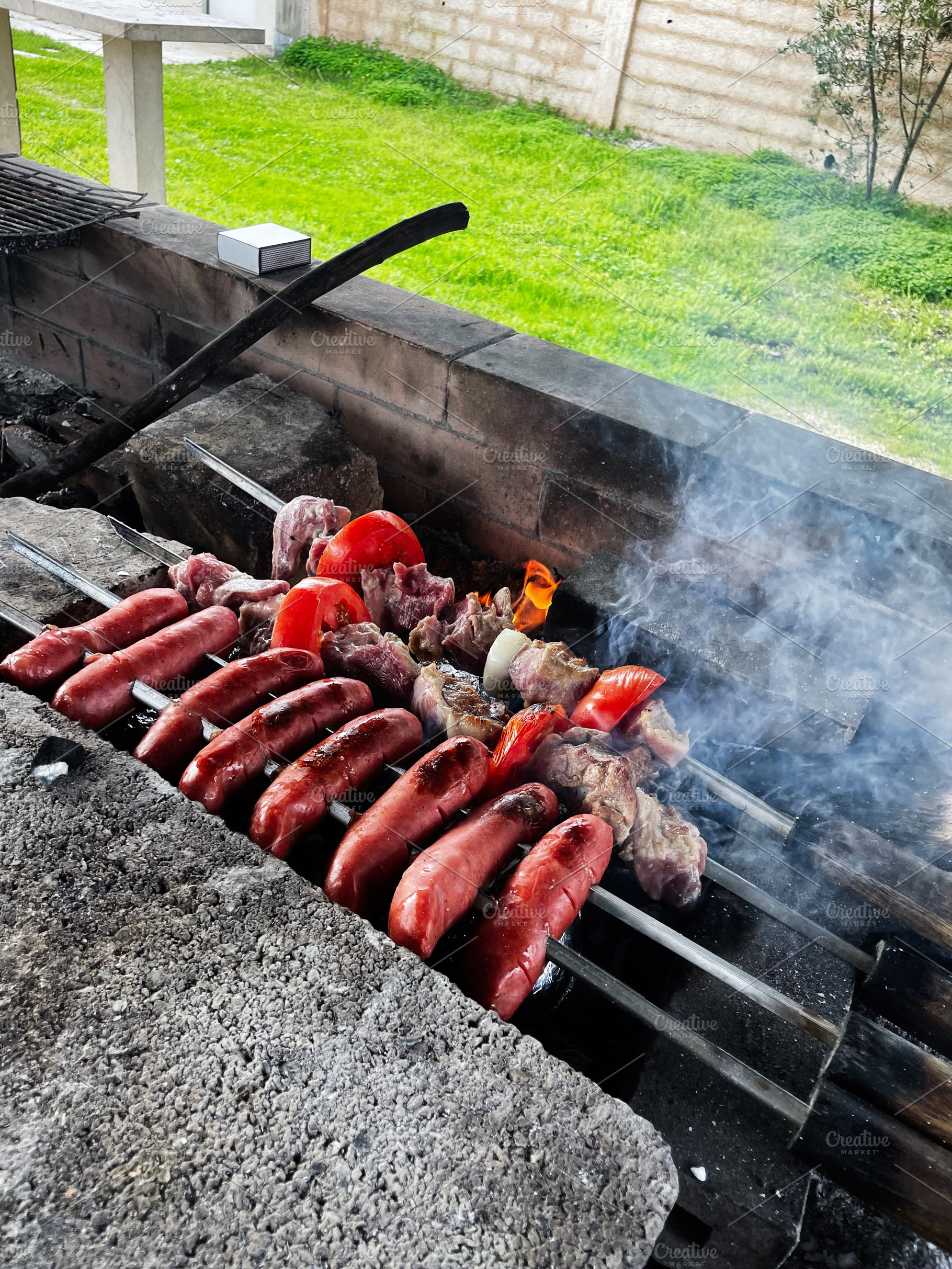 Barbecue with sausages and vegetables in a backyard., a Photo by AS photostudio