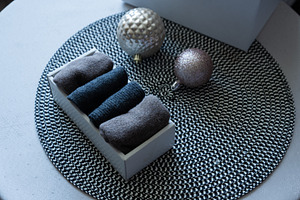Folded knit textiles in box with Christmas ornaments on table, an Industrial Photo by MDBildes