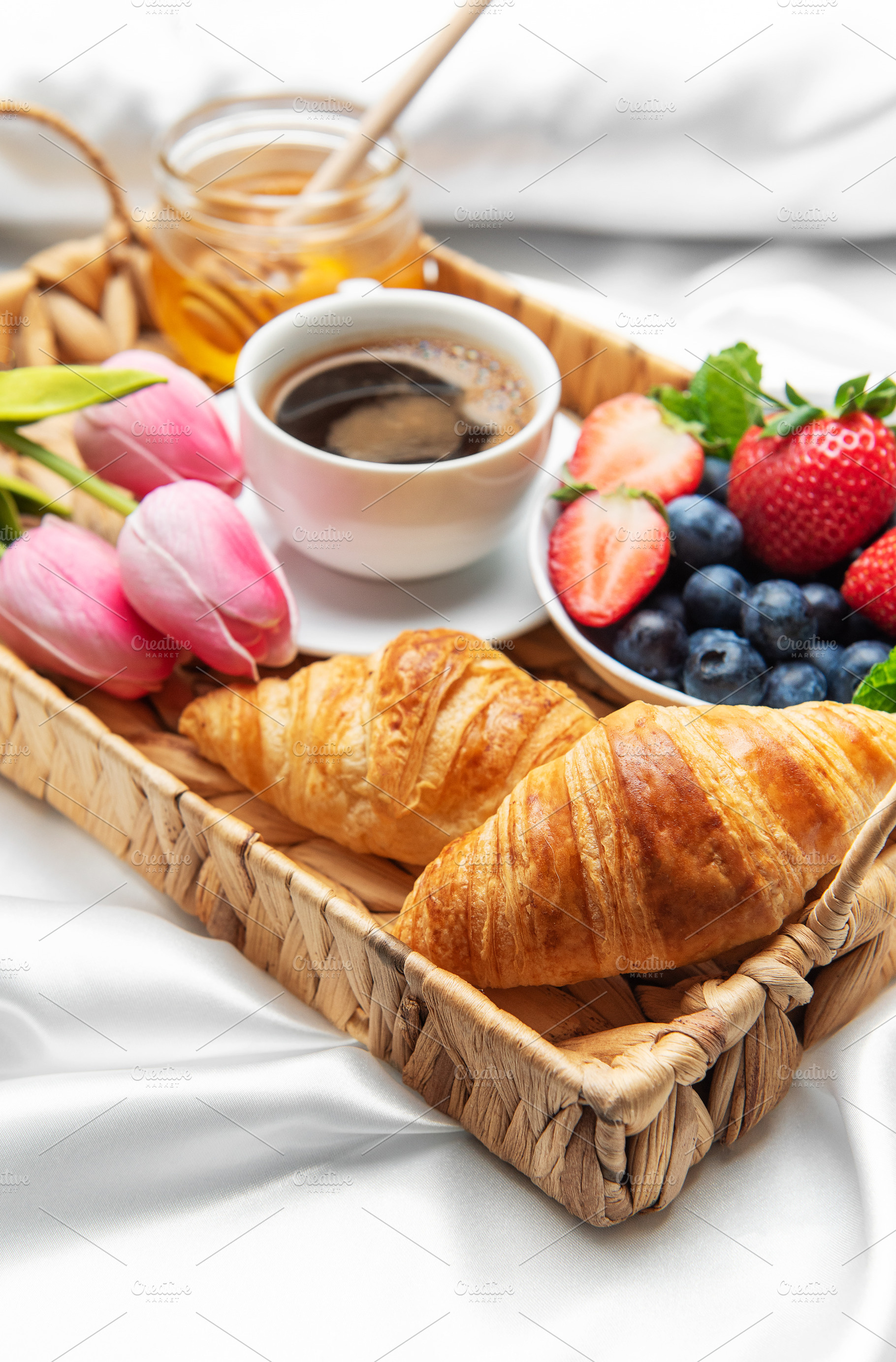 Romantic breakfast in bed with coffee, croissants, berries, hone, a Food & Drink Photo by Olena Rudo