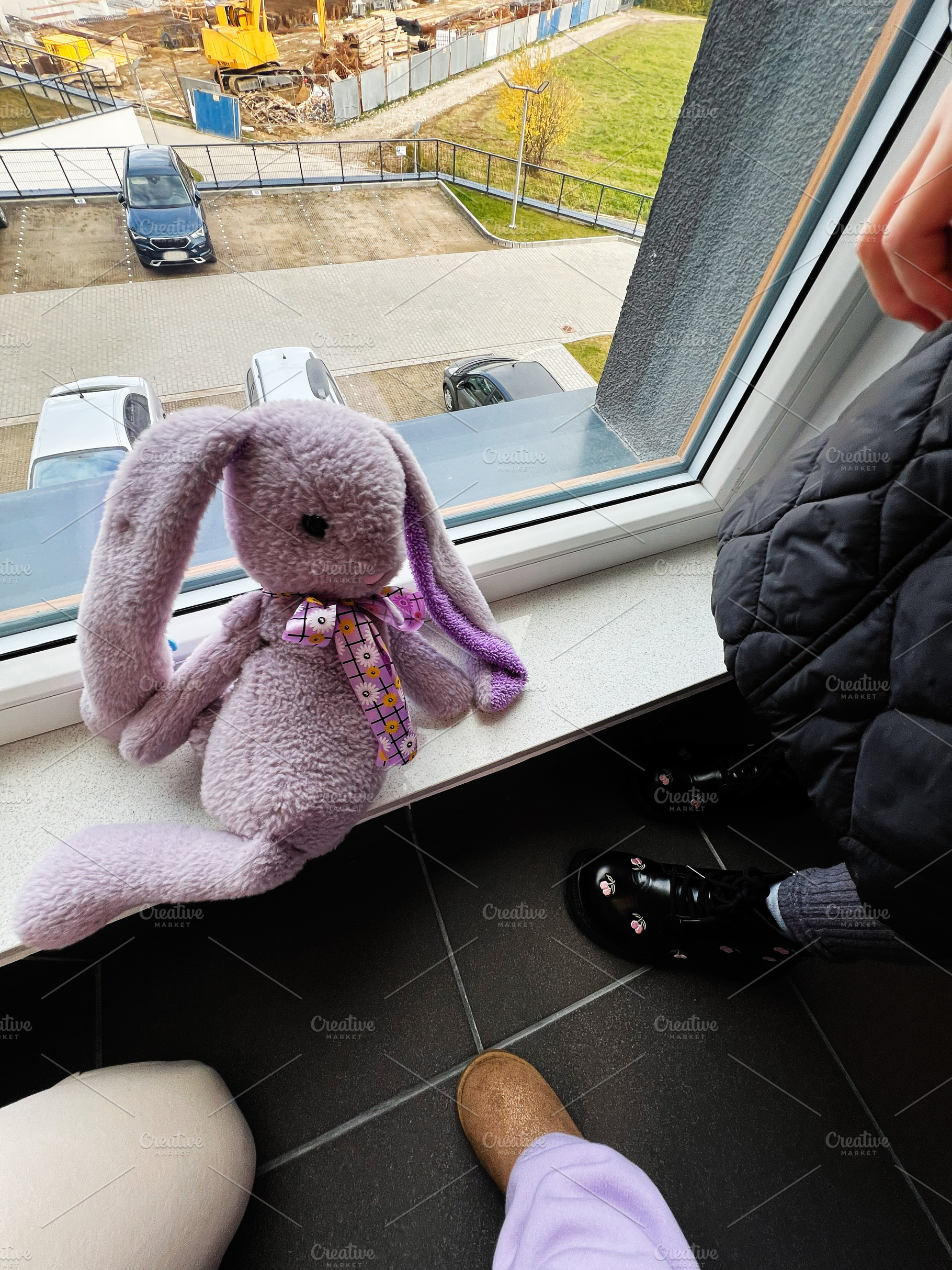 Soft lavender bunny plush toy on windowsill with purple scarf overlooking const, a Photo by AS photostudio