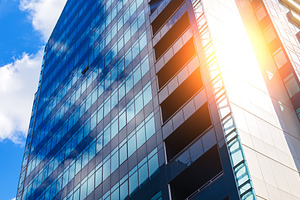 blue glass modern business center in summer with sun behind