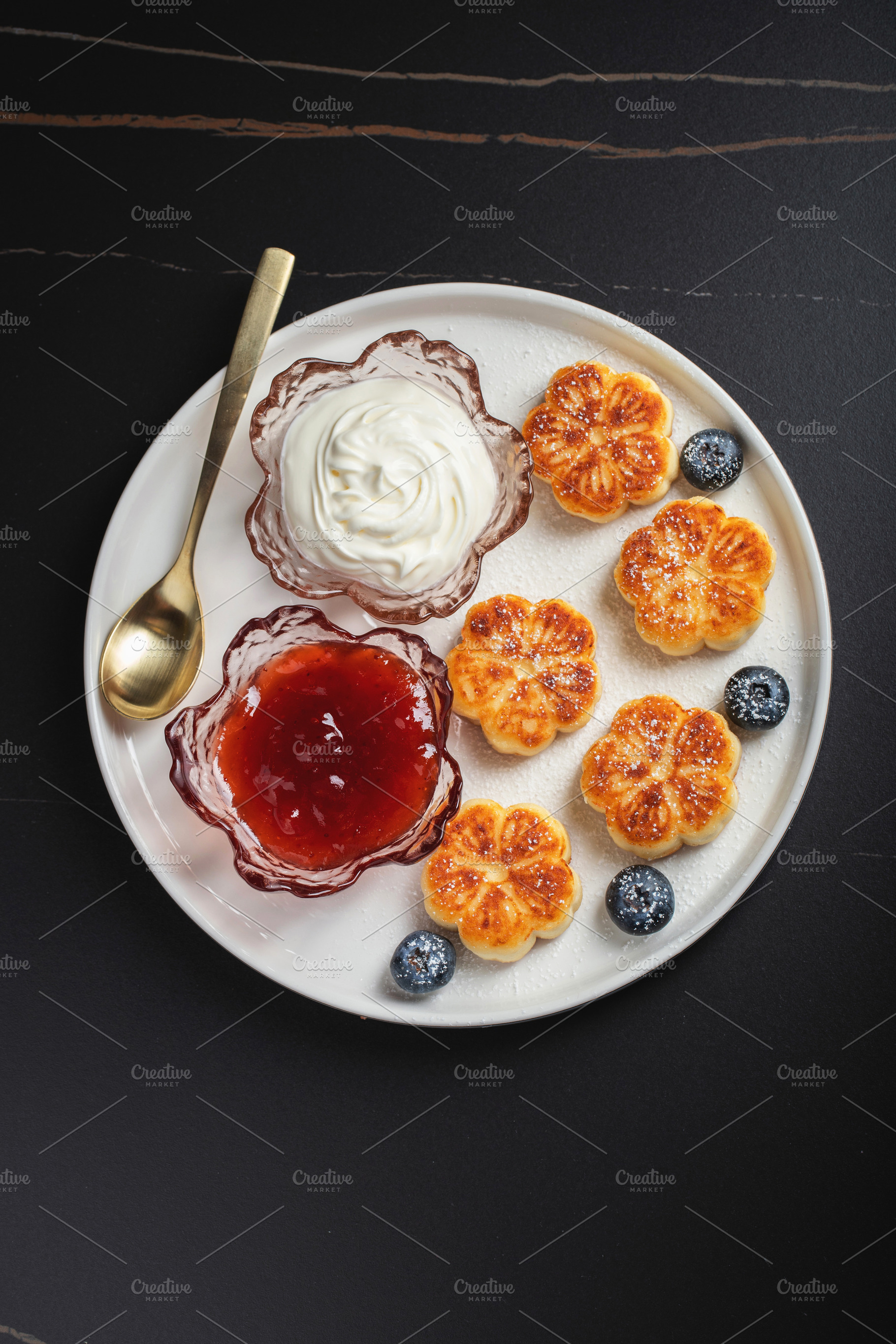 Cottage cheese pancakes, syrniki, curd fritters decorated with strawberry and r, a Food & Drink Photo by Budarinphoto