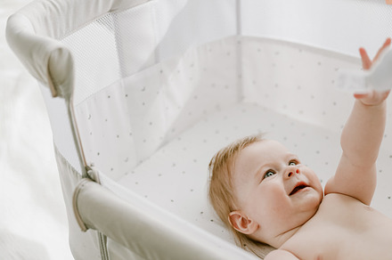 Cute little baby girl lying in the bed crib and playing with hanging mobile toy, a Person Photo by Lenor4ik