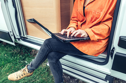 Woman teleworking sitting in the door of campervan, a Person Photo by davidpereiras