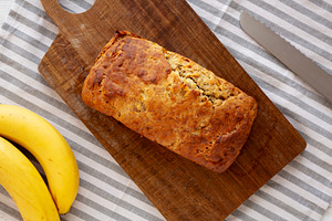 Homemade Banana Bread on a wooden board, top view. Overhead, fro, a Food & Drink Photo by LiudmylaChuhunova