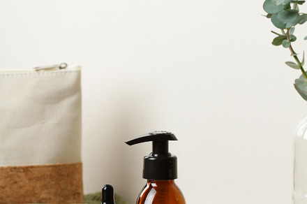 Brown amber glass cosmetic bottles on wooden tray on table with cosmetic bag an, a Health & Medical Photo by photoguns