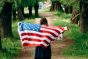 The girl carries the American flag.