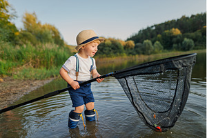 Boy standing in water with fishing, a Nature Photo by HalfPoint