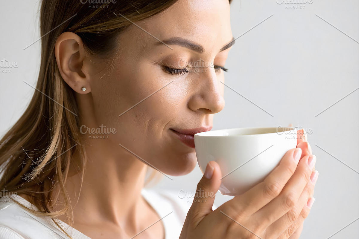 Woman enjoying morning tea with gentle satisfied expression, a Person Photo by GoodGoods (Photo 2 of 2)