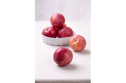 Red plum in a white ceramic bowl on, a Food & Drink Photo by Diary of impressions