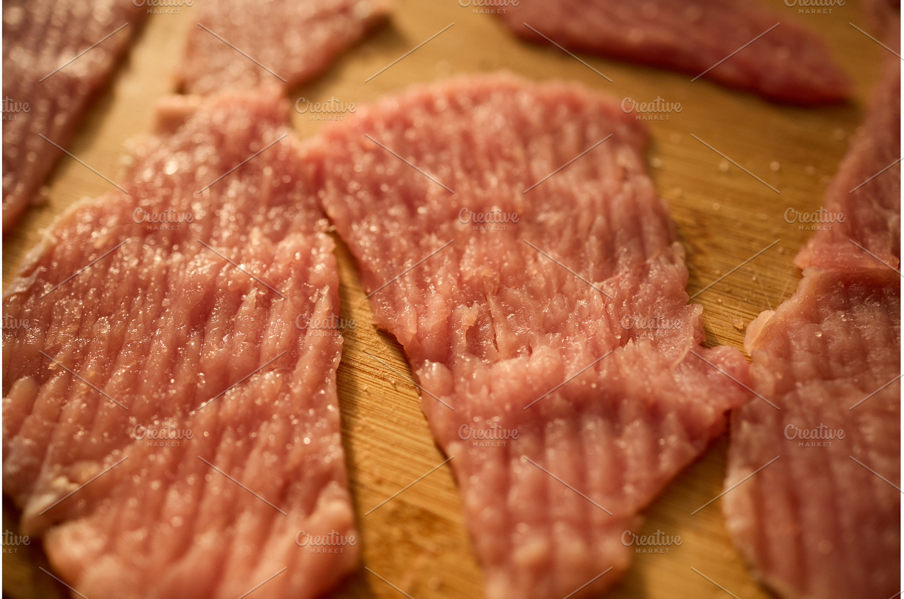 Slices of raw meat arranged on a, a Food & Drink Photo by IlliaBondarPhotography