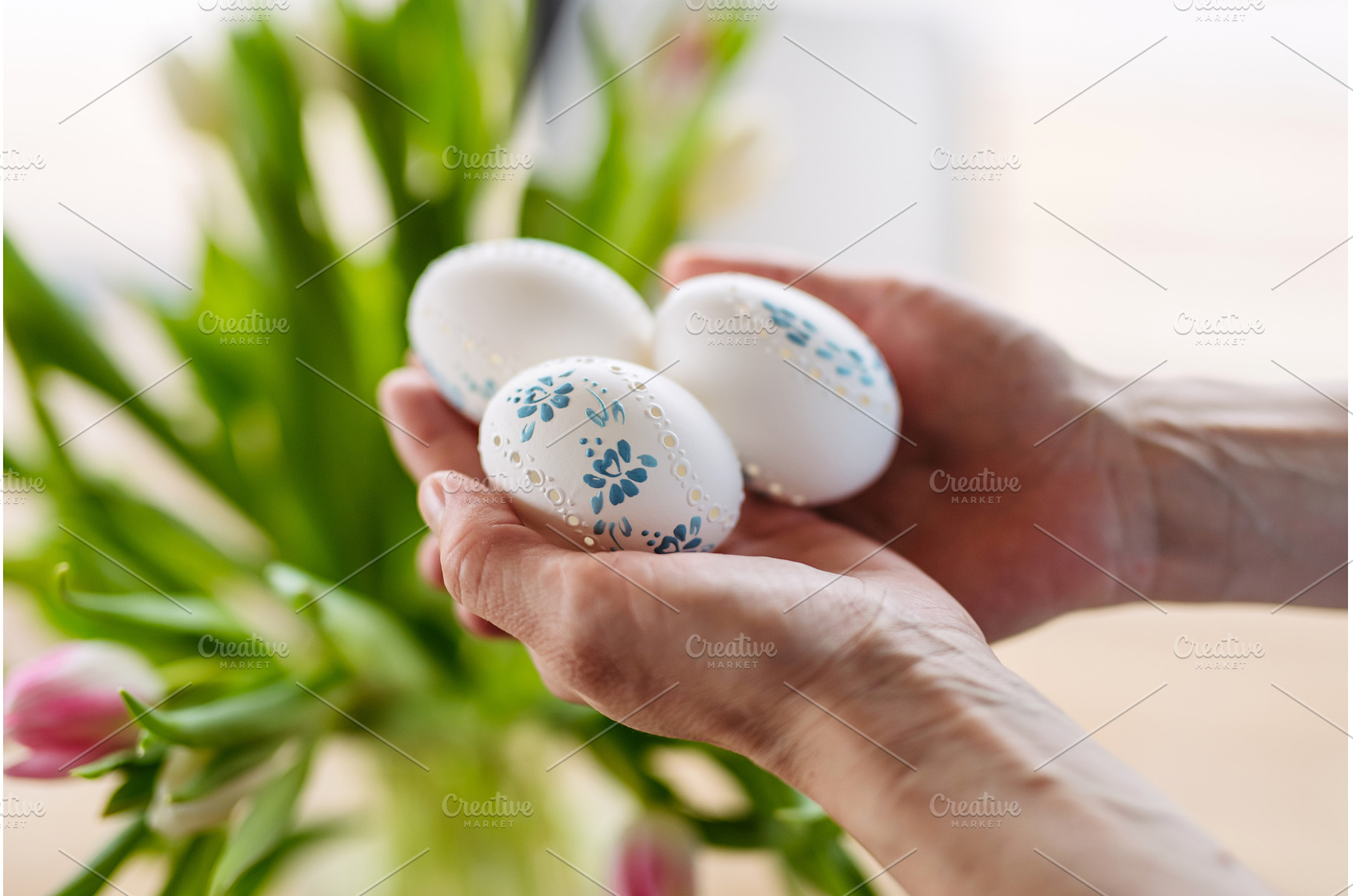 Hands holding decorated Easter eggs, a Holiday Photo by HalfPoint