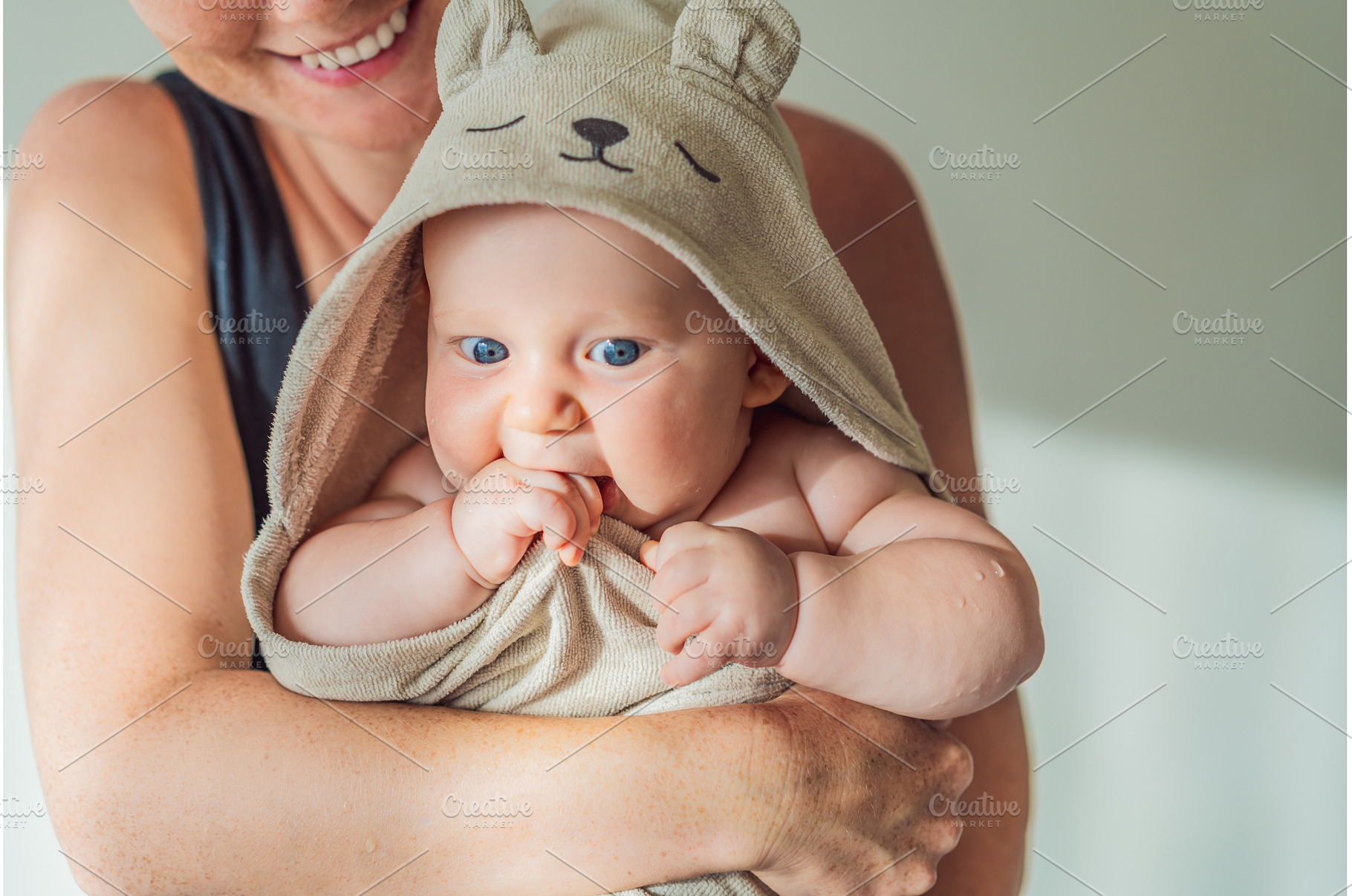 Mother holding her baby wrapped in a, a Person Photo by Elizaveta Galitskaya