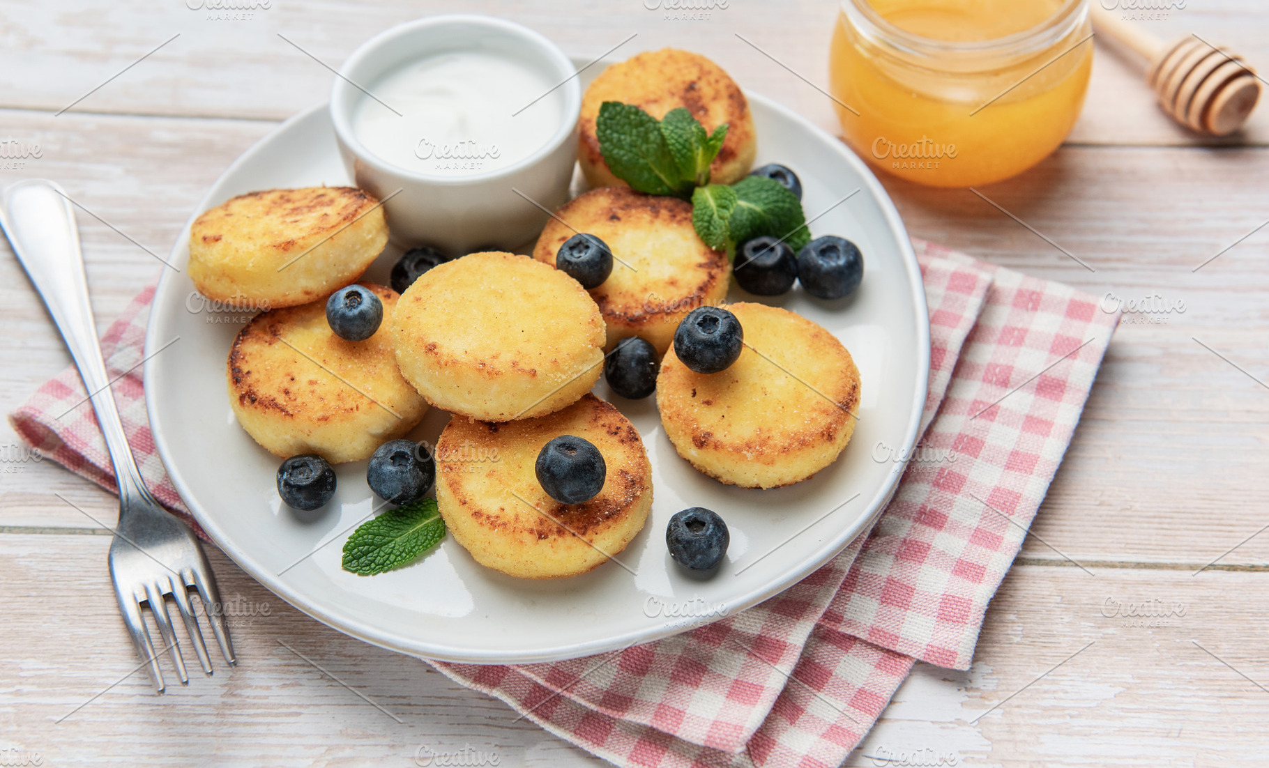 Sirniki cheese pancakes with blueberries honey and sour cream, a Food & Drink Photo by Olena Rudo