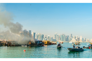 Traditional arabic dhow on fire in doha qatar featuring doha, qatar, and boat, a Transportation Photo by Leonid Andronov
