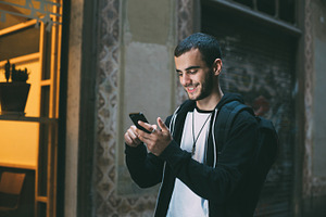 Handsome millennial uses phone